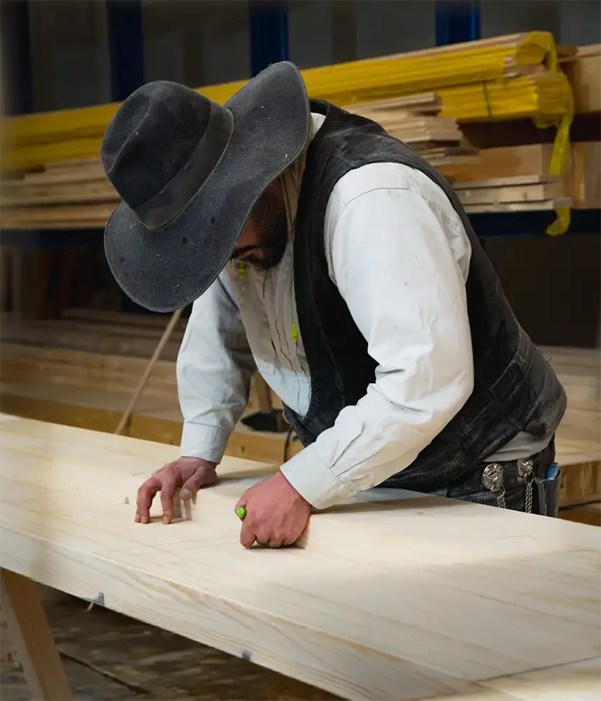 Thomas Blum in der Zimmerei beim Bearbeiten eines Holzelements.